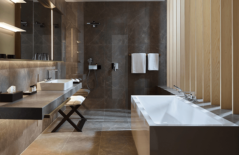 Elegantes Bad mit dunklen Marmorfliesen und freistehender Wanne